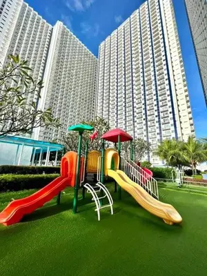 a playground with slides in front of a large building at Your Urban Oasis in the Heart of Makati in Manila