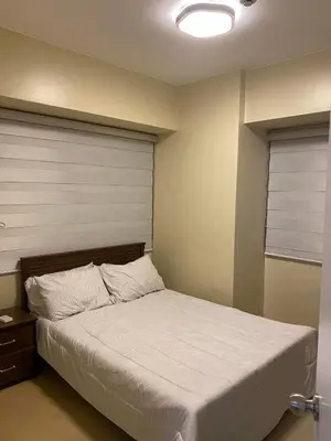 a bedroom with a bed with a white bedspread at Stylish 1bedroom apartment at Muntinlupa in Manila
