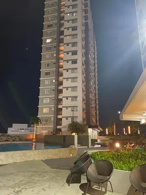 a tall building with two chairs in front of it at Stylish 1bedroom apartment at Muntinlupa in Manila