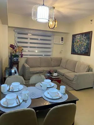 a living room with a couch and a table with dishes on it at Stylish 1bedroom apartment at Muntinlupa in Manila