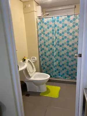 a bathroom with a toilet and a sink and a shower at Stylish 1bedroom apartment at Muntinlupa in Manila