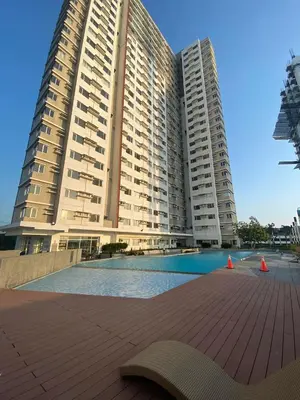a large apartment building with a pool in front of it at Stylish 1bedroom apartment at Muntinlupa in Manila