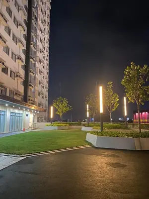 a night view of a park with trees and buildings at Stylish 1bedroom apartment at Muntinlupa in Manila