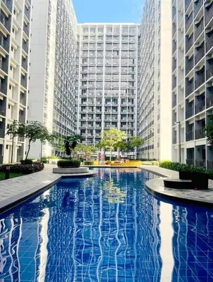 a large blue swimming pool in front of tall buildings at Pikamon - 15 mins to Airport - Arcade - Shore 2 - MOA in Manila