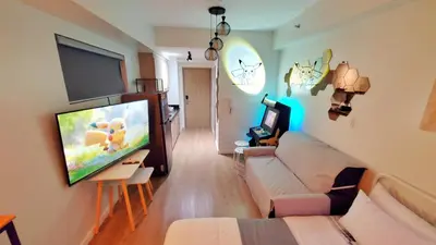 a living room with a couch and a flat screen tv at Pikamon - 15 mins to Airport - Arcade - Shore 2 - MOA in Manila