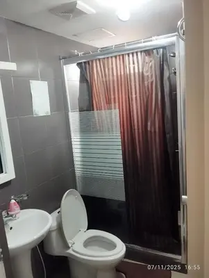 a bathroom with a shower and a toilet and a sink at HAPpycation Portocondo in Manila