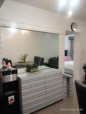 a living room with a large mirror and a bedroom at HAPpycation Portocondo in Manila