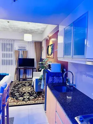 a kitchen with a sink and a living room at We Vibe, 101 Newport Blvd near the airport NAIA 3 in Manila