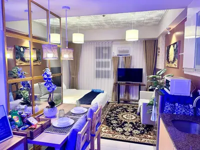 a living room with a dining table and a living room with a couch at We Vibe, 101 Newport Blvd near the airport NAIA 3 in Manila