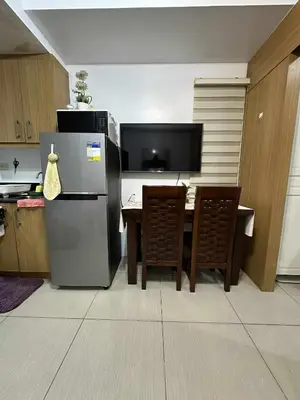 a kitchen with a refrigerator and a table with chairs at Shell residences Tower D in Manila