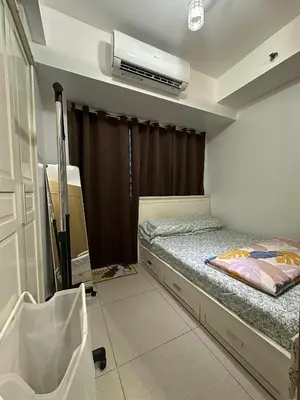 a bedroom with a bed and a air conditioner at Shell residences Tower D in Manila