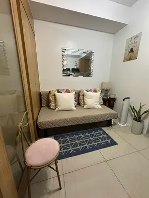 a room with a couch and a chair and a mirror at Shell residences Tower D in Manila