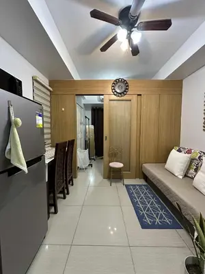 a living room with a couch and a ceiling fan at Shell residences Tower D in Manila