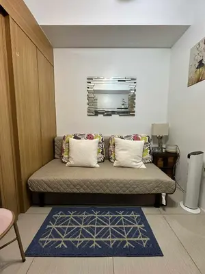 a room with a bed with pillows and a mirror at Shell residences Tower D in Manila
