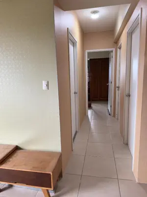 a hallway with a bench and some doors at Leos room in Manila