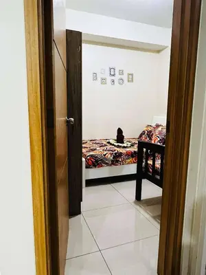 a room with a bed and a cat sitting on a bed at Shell Residences -weng's-place in Manila