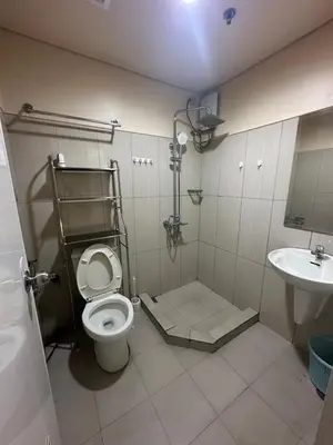 a bathroom with a toilet and a sink at Shell Residences -weng's-place in Manila