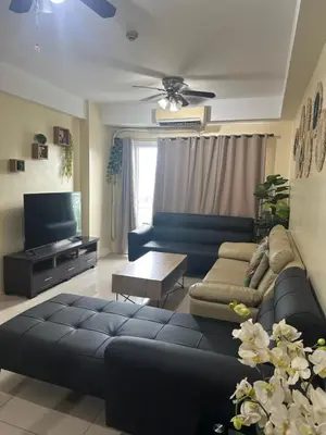 a living room with a couch and a tv at Shell Residences -weng's-place in Manila