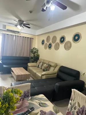 a living room with couches and a ceiling fan at Shell Residences -weng's-place in Manila