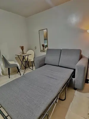 a couch in a room with a table and chairs at Condotel Near NAIA T1, T2 and CAAP in Manila