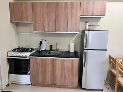 a kitchen with a sink and a white refrigerator at New 1BR in Mandaluyong 40SQM in Manila