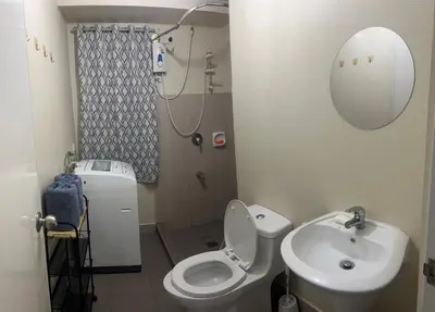 a bathroom with a toilet and a sink and a mirror at New 1BR in Mandaluyong 40SQM in Manila