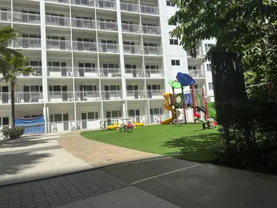 a large apartment building with a playground in front of it at Koro Den at Shore Residences in Manila