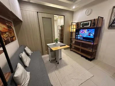 a living room with a couch and a tv at Koro Den at Shore Residences in Manila