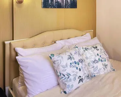 a bed with white and blue pillows on it at Charm's City Escape at Grace Residences in Manila