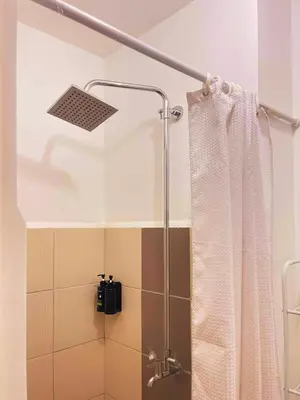 a shower with a shower curtain in a bathroom at Charm's City Escape at Grace Residences in Manila