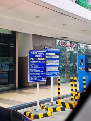 two signs in front of a shopping center with a store at Charm's City Escape at Grace Residences in Manila