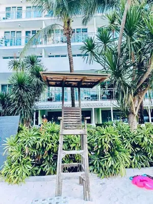 a wooden lifeguard stand on a beach with palm trees at Azure Urban Resort Residences Parañaque City in Manila