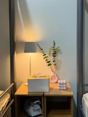 a table with a laptop and a lamp on it at Roomies Spacious Fully Furnished Condo with Balcony and Netflix for 4pax in Manila