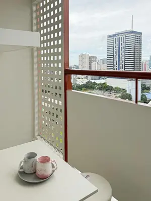 a table with two cups and a plate on a balcony at Roomies Spacious Fully Furnished Condo with Balcony and Netflix for 4pax in Manila