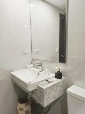 a white bathroom with a sink and a mirror at Condo- Park McKinleyWest Big1Br unit -Pool View in Manila