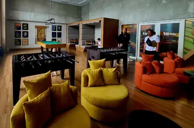 two people standing in a room with a ping pong room at Condo- Park McKinleyWest Big1Br unit -Pool View in Manila