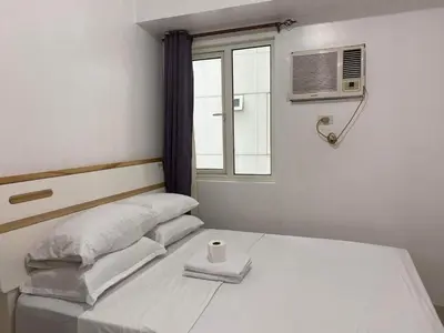 a bedroom with a bed and a window with a cup on it at Shore Residence 2br 5f walking distance MOA near airport in Manila