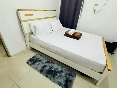 a small bedroom with a bed with a towel on it at Shore Residence 2br 5f walking distance MOA near airport in Manila