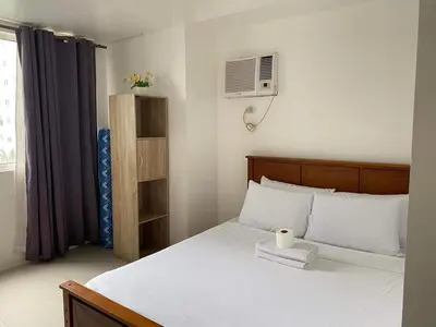a bedroom with a bed with a white candle on it at Shore Residence 2br 5f walking distance MOA near airport in Manila