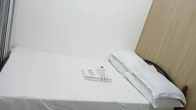 a bed with white sheets and pillows in a room at SHORE Residence d42 walking distance MOA near Airport in Manila
