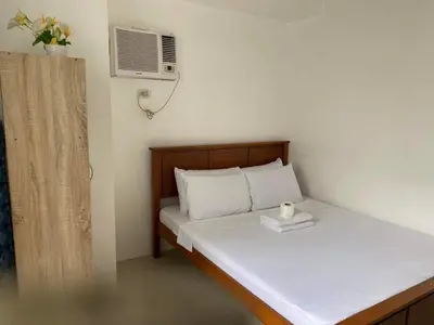 a small bedroom with a bed with a candle on it at SHORE Residence d42 walking distance MOA near Airport in Manila