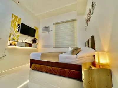 a bedroom with two beds and a television in it at Sky Condotel Staycation in Manila