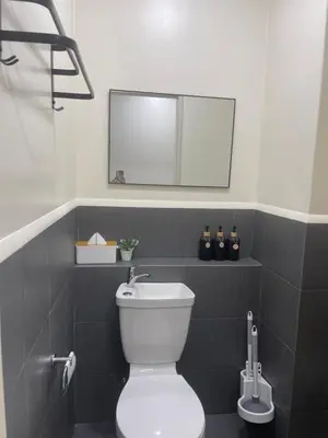 a bathroom with a white toilet and a mirror at Sky Condotel Staycation in Manila