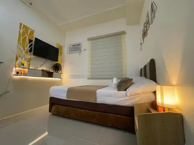 a bedroom with a bed and a television in it at Sky Condotel Staycation in Manila
