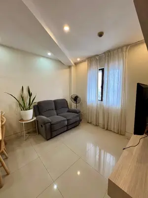 a living room with a couch and a television at SRR NAIA T3 - Month of January - New Year PROMO Php 1,999 - 1 BR Interior Designed Unit in Manila