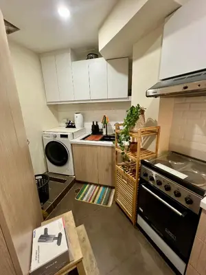 a small kitchen with a stove and a dishwasher at SRR NAIA T3 - Month of January - New Year PROMO Php 1,999 - 1 BR Interior Designed Unit in Manila