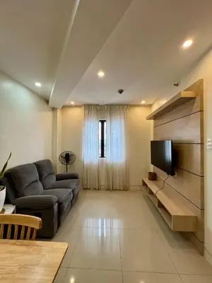 a living room with a couch and a television at SRR NAIA T3 - Month of January - New Year PROMO Php 1,999 - 1 BR Interior Designed Unit in Manila