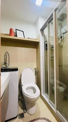 a bathroom with a toilet and a sink and a shower at Luna Suite in Manila