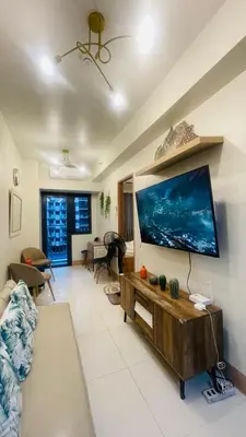a living room with a large flat screen tv on a wall at Luna Suite in Manila