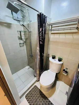 a bathroom with a shower and a toilet and a shower at Erin's Place in Manila